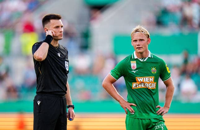 SOCCER - UEFA ECL, Rapid vs Paide VIENNA,AUSTRIA,12.AUG.26 - SOCCER - UEFA Conference League, qualification, SK Rapid Wien vs Paide Linnameeskond. Image shows referee Denys Shurman and Tobias Gulliksen (Rapid).  GEPAxpictures xEdgarxEisner