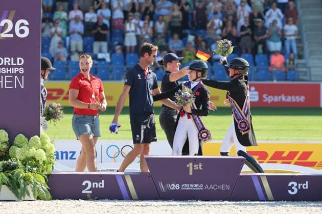 Siegerehrung mit Pflegern an der Seite der Reiter, Grooms, Medaillen: 1. Platz Charlotte Fry (GBR, Grossbritanien, Great Britain, Vereinigtes Königreich) Pferd Glamourdale, 2. Platz Cathrine Laudrup-Dufour (DEN, Dänemark, Denmark) Pferd Mount St John Freestyle, 3. Platz, Bronze, Katharina Hemmer (GER, Deutschland, Germany), Denoix PCH, Dressur, FEI Dressage World Championship, WM, Weltmeisterschaft MEGGLE-Preis, Grand Prix Special, Einzelwertung , AACHEN - FEI World Championships 2026, Weltfest des Pferdesports, Reitsport Weltmeisterschaft 2026, Aachen 2026, Welcome Home 2026, Aachener Soers, 11. bis 23. August 2026, Reitsport, 14.08.2026, Aachen Aachener Soers Deutschland *** Awards ceremony with grooms standing alongside the riders, Grooms, Medals: 1st place Charlotte Fry GBR, Great Britain, United Kingdom, Horse Glamourdale, 2nd place: Cathrine Laudrup Dufour DEN, Denmark, Denmark, horse: Mount St John Freestyle, 3rd place, bronze: Katharina Hemmer GER, Germany, Germany, Denoix PCH, Dressage, FEI Dressage World Championship MEGGLE Prize, Grand Prix Special, Individual Classification, AACHEN FEI World Championships 2026, World Festival of Equestrian Sports, 2026 Equestrian World Championships, Aachen 2026, Welcome Home 2026, Aachen Soers, August 11–23, 2026, Equestrian Sports, August 14, 2026, Aachen Soers, Germany