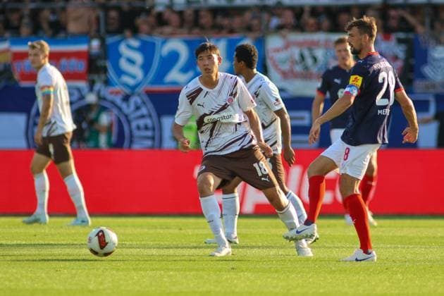 Taichi Hara ( 18; FC St. Pauli) behauptet den Ball im Mittelfeld gegen Jonas Meffert ( 28; KSV Holstein Kiel) im Holstein-Stadion in Kiel. Im Hintergrund sind weitere Spieler beider Teams sowie die Fankurve mit Fahnen und Bannern zu sehen. Taichi Hara ( 18; FC St. Pauli) im Zweikampf gegen Jonas Meffert ( 28; KSV Holstein Kiel) *** Taichi Hara (18), FC St. Pauli, holds onto the ball in midfield against Jonas Meffert (28), KSV Holstein Kiel, at Holstein Stadium in Kiel. In the background, other players from both teams can be seen, as well as the fan section with flags and banners. Taichi Hara (18), FC St. Pauli, in aagainst Jonas Meffert (28) of KSV Holstein Kiel Copyright: xspeedshotx xAndreasxTolksdorfx