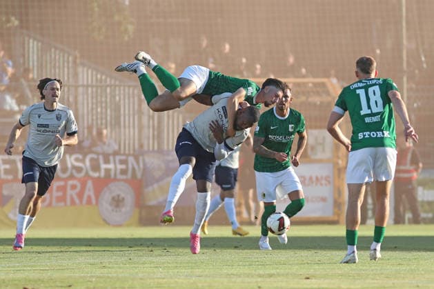 Fußball Regionalliga Nordost: BSG Chemie Leipzig - FC Carl Zeiss Jena; 14.08.2026 Valon Aliji (14, Chemie Leipzig) stürzt über Manasse Eshele (9, Carl Zeiss Jena). Fußball, Regionalliga Nordost, Saison 2026 2027, 5. Spieltag: BSG Chemie Leipzig vs. FC Carl Zeiss Jena am 14.08.2026 im Alfred-Kunze-Sportpark, Leipzig Leutzsch. *** Soccer, Northeast Regional League: BSG Chemie Leipzig vs. FC Carl Zeiss Jena, August 14, 2026; Valon Aliji (14), Chemie Leipzig, trips over Manasse Eshele (9), Carl Zeiss Jena; Soccer, Northeast Regional League, 2026–2027 season, Matchday 5: BSG Chemie Leipzig vs. FC Carl Zeiss Jena on August 14, 2026, at Alfred Kunze Sportpark, Leipzig-Leutzsch Copyright: xBEAUTIFULxSPORTS JanxKaeferx