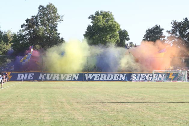 Fußball Regionalliga Nordost: BSG Chemie Leipzig - FC Carl Zeiss Jena; 14.08.2026 Choreo mit bunter Pyro im Fan-Block von Carl Zeiss Jena zum Streit um die Regionalliga-Reform: DIE KURVEN WERDEN SIEGEN. Fußball, Regionalliga Nordost, Saison 2026 2027, 5. Spieltag: BSG Chemie Leipzig vs. FC Carl Zeiss Jena am 14.08.2026 im Alfred-Kunze-Sportpark, Leipzig Leutzsch. *** Soccer, Northeast Regional League: BSG Chemie Leipzig vs. FC Carl Zeiss Jena, August 14, 2026. Choreographed display with colorful pyrotechnics in the Carl Zeiss Jena fan section regarding the dispute over the Regional League reform. THE FANS WILL PREVAIL. Soccer, Northeast Regional League, 2026–2027 season, Matchday 5: BSG Chemie Leipzig vs. FC Carl Zeiss Jena on August 14, 2026, at Alfred Kunze Sportpark, Leipzig Leutzsch Copyright: xBEAUTIFULxSPORTS JanxKaeferx