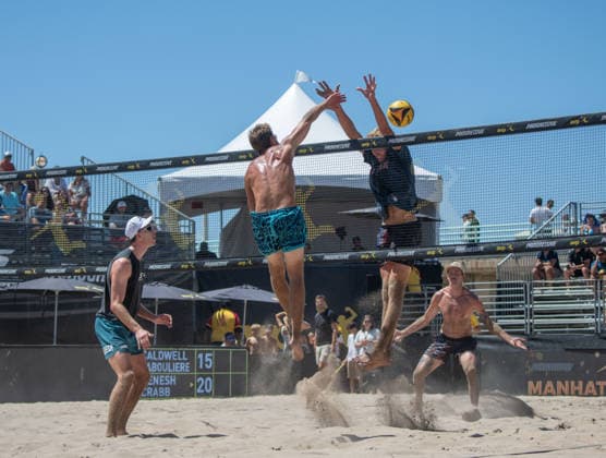 August 14, 2026, Manhattan Beach, California, USA: TAYLOR CRABB (center) spikes a ball over the net as JACOB LABOULIERE attempts the block in their second round match at the Manhattan Beach Open. Manhattan Beach USA - ZUMAl183 20260814_znp_l183_018 Copyright: xJasenxLaksx
