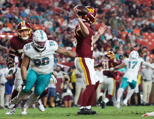 August 14, 2026, Landover, Maryland, USA: Miami Dolphins defensive tackle Alex Huntley (96) looks to sack Washington Commanders quarterback Athan Kaliakmanis (16) as he throws a pass during the NFL, American Football Herren, USA preseason game between the Washington Commanders and Miami Dolphins at Northwest Stadium on Friday, August 14, 2026; Landover, Maryland, USA. Landover USA - ZUMAs325 20260814_zsp_s325_096 Copyright: xJessxStilesx