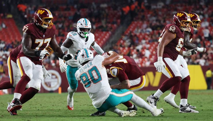August 14, 2026, Landover, Maryland, USA: Washington Commanders quarterback Athan Kaliakmanis (16) is tackled during the NFL, American Football Herren, USA preseason game between the Washington Commanders and Miami Dolphins at Northwest Stadium on Friday, August 14, 2026; Landover, Maryland, USA. Landover USA - ZUMAs325 20260814_zsp_s325_125 Copyright: xJessxStilesx