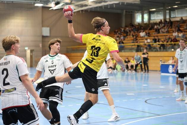 Joschua Braun ( 23; TSV St. Ottmar St. Gallen) zieht im Sprung zum Wurf ab, während Anders Thomassen ( 5; Helsingborg HK) als Abwehrspieler versucht, den Abschluss zu stören. Im Hintergrund verfolgen zahlreiche Zuschauer in der Hansehalle das Spiel. Joschua Braun ( 23; TSV St. Ottmar St. Gallen) beim Sprungwurf gegen Helsingborg HK *** Joschua Braun, No. 23 of TSV St. Ottmar St. Gallen, goes up for a jump shot, while Anders Thomassen (No. 5) of Helsingborg HK, as a defender, tries to block the shot. In the background, numerous spectators in the Hansehalle watch Joschua Braun (No. 23) of TSV St. Ottmar St. Gallen attempt a jump shot against Helsingborg HK. Copyright: xspeedshotx