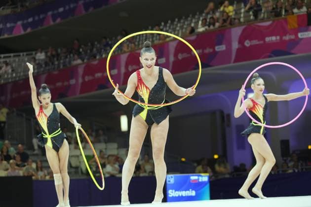 Drei Turnerinnen des slowenischen Ensembles präsentieren ihre Gruppenübung mit Reifen in der Festhalle Frankfurt. Die Anzeigetafel im Hintergrund zeigt Slovenia und bestätigt den Auftritt bei der Weltmeisterschaft 2026. Slowenisches Ensemble mit Reifen bei der Rhythmischen Sportgymnastik-WM Frankfurt *** Three gymnasts from the Slovenian ensemble perform their group routine with hoops at the Festhalle in Frankfurt. The scoreboard in the background displays Slovenia, confirming their participation in the 2026 World Championships. Slovenian ensemble performing with hoops at the Rhythmic Gymnastics World Championships in Frankfurt Copyright: xspeedshotx
