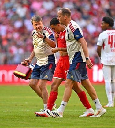 15.08.2026, Fussball Bundesliga 2026 2027, Testspiel Telecom-Cup, FC Bayern München - RB Leipzig, in der Allianz-Arena München, Teamarzt Jochen Hahne (re, FC Bayern München) mit Jamal Musiala (mitte, Bayern München) *** August 15, 2026, 2026–2027 Bundesliga, Telecom Cup Friendly, FC Bayern Munich vs. RB Leipzig, at the Allianz Arena in Munich, team doctor Jochen Hahne (right), FC Bayern Munich with Jamal Musiala (center), Bayern Munich