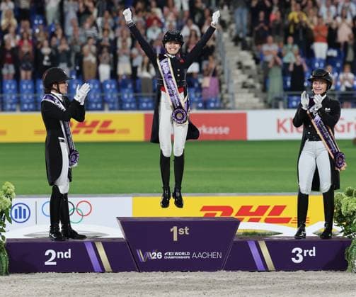 Siegerehrung: Jubel der Weltmeisterin Charlotte Fry (GBR, Grossbritanien, Great Britain, Vereinigtes Königreich) , 2. Platz, Silber, Cathrine Laudrup-Dufour (DEN, Dänemark, Denmark), 3. Platz, Bronze, Isabell Werth (GER, Deutschland, Germany) , Podium, Dressur, FEI Dressage World Championship, WM, Weltmeisterschaft Lindt-Preis, Grand Prix Kür unter Flutlicht, FEI Dressage World Championship, Individual Grand Prix Freestyle Lindt-Prize, Einzelwertung , AACHEN - FEI World Championships 2026, Weltfest des Pferdesports, Reitsport Weltmeisterschaft 2026, Aachen 2026, Welcome Home 2026, Aachener Soers, 11. bis 23. August 2026, Reitsport, 14.08.2026, - *** Awards Ceremony: World Champion Charlotte Fry GBR (Great Britain, United Kingdom) celebrates; 2nd place, silver: Cathrine Laudrup Dufour DEN (Denmark); 3rd place, bronze: Isabell Werth GER, Germany, Podium, Dressage, FEI Dressage World Championship, Lindt Prize, Grand Prix Freestyle under floodlights, FEI Dressage World Championship, Individual Grand Prix Freestyle Lindt Prize, Individual Competition, AACHEN FEI World Championships 2026, World Festival of Equestrian Sports, 2026 Equestrian World Championships, Aachen 2026, Welcome Home 2026, Aachen Soers, August 11–23, 2026, Equestrian Sports, August 14, 2026,