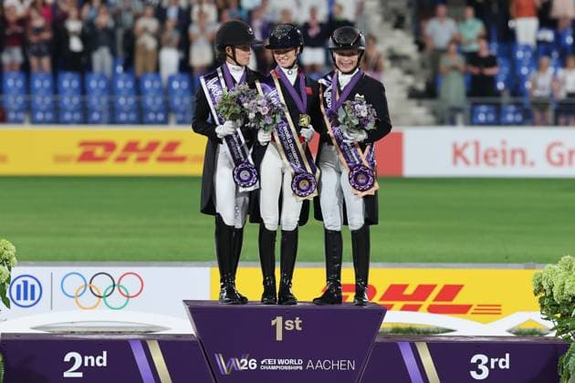 Siegerehrung: Jubel der Weltmeisterin Charlotte Fry (GBR, Grossbritanien, Great Britain, Vereinigtes Königreich) , 2. Platz, Silber, Cathrine Laudrup-Dufour (DEN, Dänemark, Denmark), 3. Platz, Bronze, Isabell Werth (GER, Deutschland, Germany) , Podium, Dressur, FEI Dressage World Championship, WM, Weltmeisterschaft Lindt-Preis, Grand Prix Kür unter Flutlicht, FEI Dressage World Championship, Individual Grand Prix Freestyle Lindt-Prize, Einzelwertung , AACHEN - FEI World Championships 2026, Weltfest des Pferdesports, Reitsport Weltmeisterschaft 2026, Aachen 2026, Welcome Home 2026, Aachener Soers, 11. bis 23. August 2026, Reitsport, 14.08.2026, - *** Awards Ceremony: World Champion Charlotte Fry GBR (Great Britain, United Kingdom) celebrates; 2nd place, silver: Cathrine Laudrup Dufour DEN (Denmark); 3rd place, bronze: Isabell Werth GER, Germany, Podium, Dressage, FEI Dressage World Championship, Lindt Prize, Grand Prix Freestyle under floodlights, FEI Dressage World Championship, Individual Grand Prix Freestyle Lindt Prize, Individual Competition, AACHEN FEI World Championships 2026, World Festival of Equestrian Sports, 2026 Equestrian World Championships, Aachen 2026, Welcome Home 2026, Aachen Soers, August 11–23, 2026, Equestrian Sports, August 14, 2026,