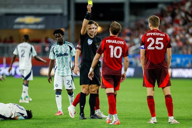 Toronto FC v New England Revolution Referee Joseph Dickerson (R) shows a yellow card to a Toronto FC player during a Major League Soccer match between Toronto FC and the New England Revolution at BMO Field in Toronto, Ontario, Canada, on August 15, 2026. Toronto Ontario Canada  Copyright: xIndrawanxKumalax originalFilename:kumala-majorlea260815_npRIJ.jpg