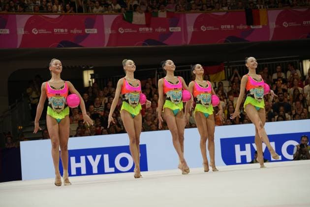 Fünf Turnerinnen einer Gruppe präsentieren ihre synchronisierte Ballübung auf dem Wettkampfteppich der Festhalle Frankfurt. Die Athletinnen tragen identische pink-gelb-türkise Wettkampfanzüge und halten je einen pinken Ball. Gruppenübung mit Ball bei der Rhythmischen Sportgymnastik-WM in Frankfurt *** Five gymnasts from a group perform their synchronized ball routine on the competition mat at the Festhalle in Frankfurt. The athletes are wearing identical pink, yellow, and turquoise competition leotards, and each is holding a pink ball. Group ball routine at the Rhythmic Gymnastics World Championships in Frankfurt Copyright: xspeedshotx