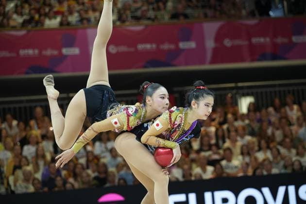 Drei Turnerinnen des japanischen Nationalteams führen eine synchronisierte Gruppenübung mit Ball bei der Weltmeisterschaft der rhythmischen Sportgymnastik 2026 in Frankfurt am Main aus. Eine Turnerin streckt das Bein hoch in die Luft, während zwei weitere den roten Ball gemeinsam halten und das vollbesetzte Publikum der Festhalle Frankfurt im Hintergrund zu sehen ist. Japanisches Gruppe-Team bei Gruppenübung mit Ball in der Festhalle Frankfurt *** Three gymnasts from the Japanese national team perform a synchronized group routine with a ball at the 2026 Rhythmic Gymnastics World Championships in Frankfurt am Main. One gymnast stretches her leg high into the air, while two others hold the red ball together, with the packed audience at Frankfurt’s Festhalle visible in the background. The Japanese group team performs a group routine with a ball at Frankfurt’s Festhalle. Copyright: xspeedshotx