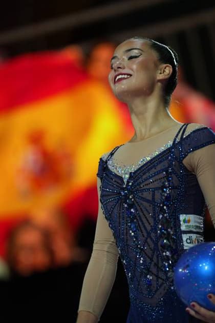 Eine Gymnastin aus Spanien hält einen blauen Ball und lächelt mit geschlossenen Augen, im Hintergrund ist die spanische Flagge zu erkennen. Das Bild entstand bei der Weltmeisterschaft der rhythmischen Sportgymnastik 2026 in der Festhalle Frankfurt. Spanische Gymnastin mit Ball und strahlendem Lächeln bei der Rhythmischen WM *** A gymnast from Spain is holding a blue ball and smiling with her eyes closed; with the Spanish flag visible in the background. The photo was taken at the 2026 Rhythmic Gymnastics World Championships in the Festhalle in Frankfurt. Spanish gymnast with a ball and a beaming smile at the Rhythmic Gymnastics World Championships Copyright: xspeedshotx