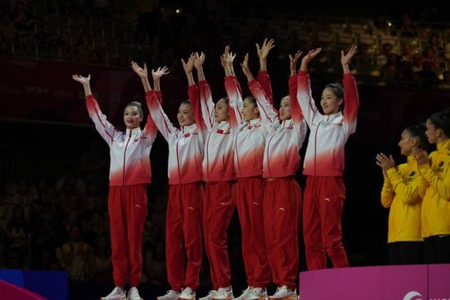 Das chinesische Gruppenteam in roten Trainingsanzügen reckt die Arme in die Höhe und feiert vor der Kulisse der voll besetzten Festhalle Frankfurt. Im Hintergrund applaudieren Athletinnen in gelben Jacken. Chinas Gruppenteam jubelt bei der Rhythmischen Sportgymnastik-WM in Frankfurt *** The Chinese team, dressed in red tracksuits, raises their arms in the air and celebrates against the backdrop of the packed Festhalle in Frankfurt. In the background, athletes in yellow jackets applaud. The Chinese team celebrates at the Rhythmic Gymnastics World Championships in Frankfurt. Copyright: xspeedshotx