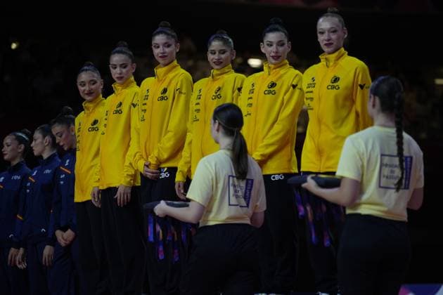 Das brasilianische Gruppenteam (CBG) steht in gelben Trainingsjacken bei der Siegerehrung der Weltmeisterschaft der Rhythmischen Sportgymnastik in der Festhalle Frankfurt. Zwei Helferinnen in hellgelben T-Shirts präsentieren die Medaillen auf Tabletts vor den Athletinnen. Brasilianische Gruppe bei Siegerehrung der Rhythmischen Sportgymnastik WM 2026 *** The Brazilian group team CBG stands in yellow training jackets at the medal ceremony for the Rhythmic Gymnastics World Championships in Frankfurt’s Festhalle. Two volunteers in light yellow T-shirts present the medals on trays in front of the athletes. Brazilian group at the medal ceremony for the Rhythmic2026 Rhythmic Gymnastics World Championships Copyright: xspeedshotx