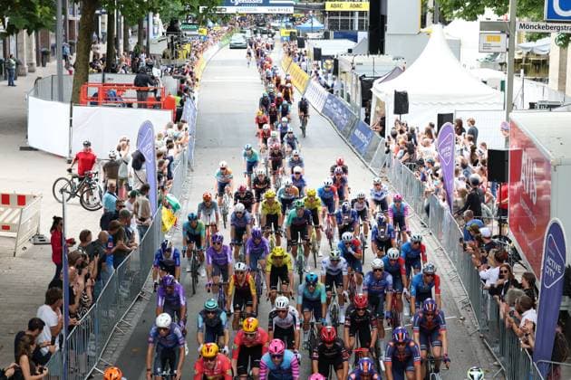 Das gesamte Peloton rollt beim Start der EuroEyes Cyclassics Hamburg durch die Innenstadt, begleitet von dichten Zuschauermassen beidseitig der Absperrungen. Im Hintergrund ist das Zielgatter mit Sponsorenlogos von Skoda, Van Rysel und ADAC zu sehen. Das Peloton beim Start der Cyclassics Hamburg am Rathausmarkt *** At the start of the EuroEyes Cyclassics Hamburg, the entire peloton rolls through the city center, accompanied by dense crowds of spectators on both sides of the barriers. In the background, the finish line gate is visible, featuring sponsor logos from Skoda, Van Rysel, and ADAC. The peloton at the start of the Cyclassics Hamburg at Rathausmarkt Copyright: xspeedshotx xSarahxWolfx