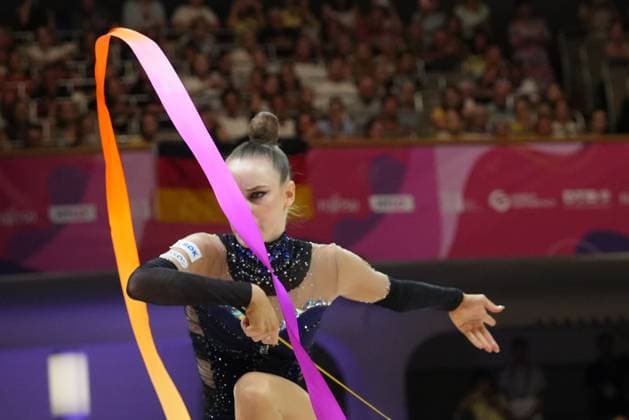 Darja Varfolomeev führt eine Bandübung bei der Weltmeisterschaft der rhythmischen Sportgymnastik 2026 in der Festhalle Frankfurt aus. Das orange-pinke Band zieht eine elegante Kurve durch das Bild, während die Athletin in konzentrierter Haltung agiert. Rhythmische Sportgymnastik WM 2026: Turnerin mit Band in der Festhalle Frankfurt *** Darja Varfolomeev performs a ribbon routine at the 2026 Rhythmic Gymnastics World Championships in Frankfurt’s Festhalle. The orange-pink ribbon traces an elegant curve across the frame, while the athlete performs with a focused demeanor. 2026 Rhythmic Gymnastics World Championships: Gymnast with a ribbon at the Festhalle Frankfurt Copyright: xspeedshotx