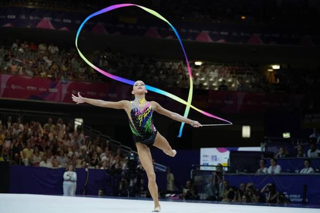 Eine Turnerin führt eine elegante Balanceübung mit einem farbenfrohen Band bei der Weltmeisterschaft der rhythmischen Sportgymnastik 2026 in der Festhalle Frankfurt aus. Das regenbogenfarbene Band beschreibt eine große Schleife über ihr, während sie auf einem Bein balanciert und die Arme ausbreitet. Rhythmische Sportgymnastik WM 2026 – Turnerin mit Band in der Festhalle Frankfurt *** A gymnast performs an elegant balancing routine with a colorful ribbon at the 2026 Rhythmic Gymnastics World Championships in Frankfurt’s Festhalle. The rainbow-colored ribbon forms a large loop above her, while she balances on one leg and spreads her arms wide. 2026 Rhythmic Gymnastics World Championships – Gymnast with a ribbon at the Festhalle in Frankfurt Copyright: xspeedshotx