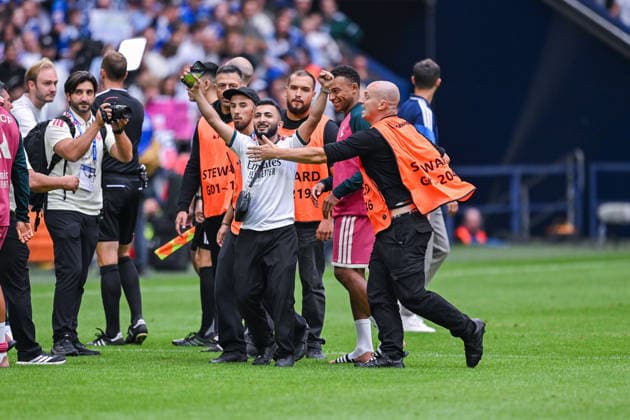 16.08.2026, Fussball, Saison 2026 2027, Testspiel, FC Schalke 04 - Real Madrid, Ein Flitzer will zu Kylian MbappÃ (Real Madrid) und freut sich über das Selfie mit ihm, xRHR-FOTO YYx *** August 16, 2026, Soccer, 2026–2027 Season, Friendly Match, FC Schalke 04 vs. Real Madrid, A streaker tries to get to Kylian Mbappé at Real Madrid and is thrilled to take a selfie with him, xRHR PHOTO YYx Copyright: KROEGER RHR-FOTOx RHR-FOTO YY
