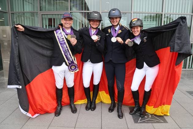 Weltmeister Michael Jung (GER) gemeinsam mit dem Silberteam, Mannschaftsilber, (v.l.), Michael Jung, Julia Krajewski, Libussa Lübbeke und Malin Hansen-Hotopp (GER), Gruppenbild mit deuscher Fahne, Vielseitigkeit , FEI Eventing World Championship, WM, Weltmeisterschaft , DHL-Preis, Einzel Mannschaft, AACHEN - FEI World Championships 2026, Weltfest des Pferdesports, Reitsport Weltmeisterschaft 2026, Aachen 2026, Welcome Home 2026, Aachener Soers, 11. bis 23. August 2026, Reitsport, 16.08.2026, Aachen Aachener Soers Deutschland *** World Champion Michael Jung (GER) together with the silver medal-winning team: Michael Jung, Julia Krajewski, Libussa Lübbeke, and Malin Hansen Hotopp (GER); group photo with the German flag; eventing; FEI Eventing World Championship; DHL Prize, Individual and Team, AACHEN FEI World Championships 2026, World Festival of Equestrian Sports, 2026 Equestrian World Championships, Aachen 2026, Welcome Home 2026, Aachen Soers, August 11–23, 2026, Equestrian Sports, August 16, 2026, Aachen Soers, Germany