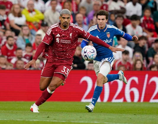 Liverpool, England, 16th August 2026. Ronald Araujo of Liverpool (L) is challenged by Maximo Perrone of Como during the Liverpool vs Como 1907 Pre Season Friendly match at Anfield, Liverpool. Picture credit should read: Andrew Yates Sportimage EDITORIAL USE ONLY. No use with unauthorised audio, video, data, fixture lists, club league logos or live services. Online in-match use limited to 120 images, no video emulation. No use in betting, games or single club league player publications. SPI_013_AY_LIVERPOOL_COMO SPI-4910-0012