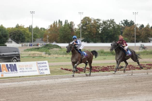 Auf der Rennbahn Berlin Mariendorf galoppieren zwei Pferde auf der Sandbahn, wobei Pferd Nr. 2 mit blau-weißem Jockey klar in Führung liegt. Pferd Nr. 8 mit bordeauxrotem Jockey folgt dicht dahinter. Jockey auf Pferd Nr. 2 führt das Rennen in Mariendorf an *** At the Berlin Mariendorf Racetrack, two horses are galloping on the dirt track, with Horse No. 2, ridden by a jockey in blue and white, clearly in the lead. Horse No. 8, ridden by a jockey in burgundy, is close behind. The jockey on Horse No. 2 is leading the race in Mariendorf. Copyright: xspeedshotx
