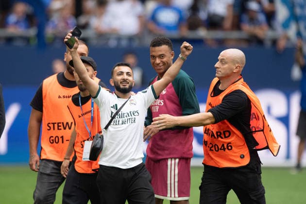 Ordner haben einen Flitzer gefangen und halten ihn am Boden fest, er jubelt nachdem er ein Selfie mit Kylian MBAPPE (Real Madrid) machen durfte, Fussball Freundschaftsspiel FC Schalke 04 - Real Madrid 0-3 am 16.08.2026 in der Veltins-Arena Gelsenkirchen Deutschland. DFL regulations prohibit any use of photographs as image sequences and or quasi-video Â *** Security guards have caught a streaker and are holding him down; he’s cheering after being allowed to take a selfie with Kylian Mbappé of Real Madrid, Soccer friendly match: FC Schalke 04 vs. Real Madrid 0–3 on August 16, 2026, at the Veltins Arena in Gelsenkirchen, Germany. DFL regulations prohibit any use of photographs as image sequences and or quasi-video.