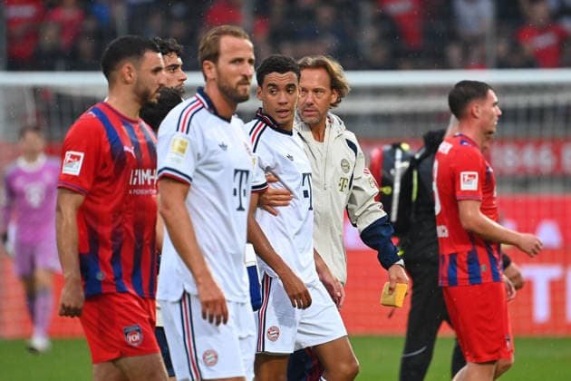 Jamal MUSIALA (Bayern Muenchen) bricht erneut zusammen,Ohnmacht, wird von Dr.Peter UEBLACKER (Mannschaftsarzt FCB) vom Platz gefuehrt, li:Harry KANE (Bayern Muenchen). Fussball Testpiel 1.FC Heidenheim - FC Bayern Muenchen am 18.08.2025 , VOITH ARENA. *** Jamal MUSIALA of Bayern Munich collapses again;faints, is led off the field by Dr. Peter UEBLACKER, FCB team doctor; featuring Harry KANE in a Bayern Munich soccer exhibition match: FC Heidenheim vs. FC Bayern Munich on August 18, 2025, at VOITH ARENA