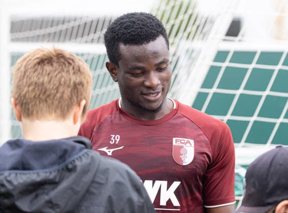 Uchenna Ogundu (FC Augsburg 39) schreibt Autogramme für die jugendlichen Fans nach dem Training; FC Augsburg, Training, *** Uchenna Ogundu of FC Augsburg 39 signs autographs for young fans after practice FC Augsburg, Practice,