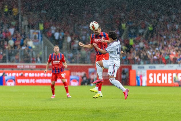 Kopfballduell Marnon Busch (1.FC Heidenheim, 02) Maycon Cardozo (FC Bayern Muenchen, 49) Regen, GER, 1. FC Heidenheim vs. FC Bayern Muenchen, Fußball, Testspiel, 2026 2027, 18.08.2026, DFL DFB REGULATIONS PROHIBIT ANY USE OF PHOTOGRAPHS AS IMAGE SEQUENCES AND OR QUASI-VIDEO, GER, 1. FC Heidenheim vs. FC Bayern Muenchen, Fußball, Testspiel, 2026 2027, 18.08.2026 Heidenheim *** Heading duel: Marnon Busch (1. FC Heidenheim), 02 Maycon Cardozo (FC Bayern Munich), 49 Regen, GER, 1. FC Heidenheim vs. FC Bayern Munich, soccer, friendly match, 2026–2027, August 18, 2026, DFL and DFB regulations prohibit any use of photographs as image sequences and or quasi-video, GER, 1 FC Heidenheim vs. FC Bayern Munich, Soccer, Friendly Match, 2026–2027, August 18, 2026, Heidenheim Copyright: xEibner-Pressefoto JanixPlessx EP_JPL