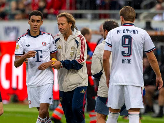 18.08.2026, Fussball Bundesliga 2026 2027, Testspiel, 1.FC Heidenheim - FC Bayern München, in der Voith-Arena Heidenheim, nach seinem erneuten Zusammenbruch während des Spieles, wird Jamal Musiala (li, Bayern München) vom Mannschaftsarzt Prof. Dr. Peter Ueblacker versorgt und vom Platz geführt. *** August 18, 2026, 2026–2027 Bundesliga season, friendly match, 1. FC Heidenheim vs. FC Bayern Munich, at the Voith Arena in Heidenheim; after collapsing again during the game, Jamal Musiala of Bayern Munich is treated by team doctor Prof. Dr. Peter Ueblacker and led off the field