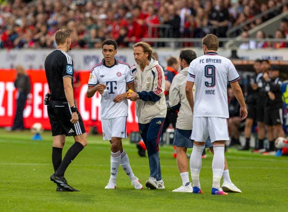 Sport Bilder des Tages #2 18.08.2026, Fussball Bundesliga 2026 2027, Testspiel, 1.FC Heidenheim - FC Bayern München, in der Voith-Arena Heidenheim, nach seinem erneuten Zusammenbruch während des Spieles, wird Jamal Musiala (mitte, Bayern München) vom Mannschaftsarzt Prof. Dr. Peter Ueblacker versorgt und vom Platz geführt. *** August 18, 2026, 2026–2027 Bundesliga season, friendly match, 1. FC Heidenheim vs. FC Bayern Munich, at the Voith Arena in Heidenheim; after collapsing again during the game, Jamal Musiala (center), of Bayern Munich, is treated by team doctor Prof. Dr. Peter Ueblacker and led off the field
