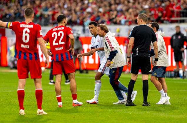 18.08.2026, Fussball Bundesliga 2026 2027, Testspiel, 1.FC Heidenheim - FC Bayern München, in der Voith-Arena Heidenheim, nach seinem erneuten Zusammenbruch während des Spieles, wird Jamal Musiala (mitte, Bayern München) vom Mannschaftsarzt Prof. Dr. Peter Ueblacker versorgt und vom Platz geführt. *** August 18, 2026, 2026–2027 Bundesliga season, friendly match, 1. FC Heidenheim vs. FC Bayern Munich, at the Voith Arena in Heidenheim; after collapsing again during the game, Jamal Musiala (center), of Bayern Munich, is treated by team doctor Prof. Dr. Peter Ueblacker and led off the field