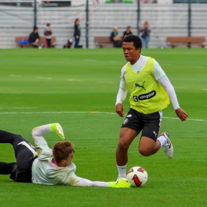 Joel Chima Fujita dribbelt im Trainingsspiel am Trainingszentrum des FC St. Pauli an einem gleitenden Gegenspieler vorbei. Der Ball liegt dabei direkt vor seinen Füßen auf dem Rasen. Joel Chima Fujita im Zweikampf beim Training des FC St. Pauli *** Joel Chima Fujita dribbles past a sliding opponent during a practice match at FC St. Pauli s training center. The ball is right at his feet on the field. Joel Chima Fujita in a one-on-one battle during FC St. Pauli s practice Copyright: xspeedshotx xAndreasxTolksdorfx