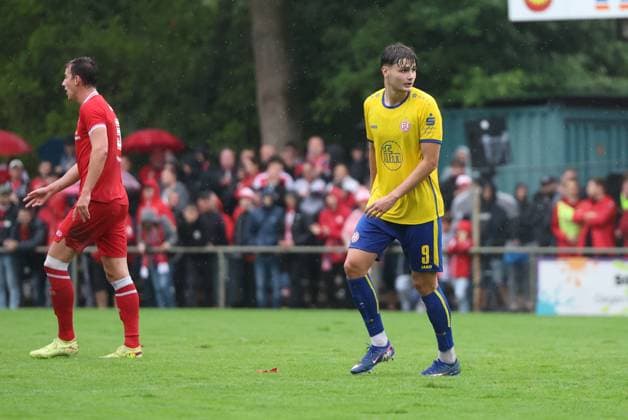 Jaka Cuber Potocnik ( 9; Rot-Weiss Essen) läuft im Regen über den Rasen des Willi-Lemkens Sportparks in Sonsbeck, im Hintergrund ein Spieler von SV Sonsbeck. Zahlreiche Zuschauer mit roten Schirmen verfolgen die Partie auf der Gegengerade. Jaka Cuber Potocnik ( 9; Rot-Weiss Essen) im Spielgeschehen gegen SV Sonsbeck *** Jaka Cuber Potocnik of Rot Weiss Essen runs across the field at Willi Lemkens Sportpark in Sonsbeck in the rain, with an SV Sonsbeck player in the background. Numerous spectators with red umbrellas watch the match from the opposite stands. Jaka Cuber Potocnik of Rot-Weiss Essen in action against SV Sonsbeck Copyright: xspeedshotx xTimoxBluhmki-Schmidtx