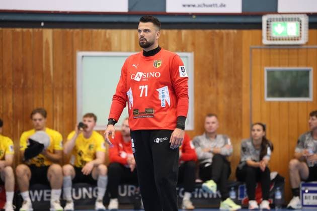 Tom Landgraf, Torwart des TSV Altenholz, steht konzentriert auf dem Spielfeld der Edgar Meschkat Halle in Altenholz. Im Hintergrund sitzen Ersatzspieler beider Teams auf der Bank. Tom Landgraf ( 71; TSV Altenholz) im Spielgeschehen *** Tom Landgraf, goalkeeper for TSV Altenholz, stands focused on the court at the Edgar Meschkat Halle in Altenholz. In the background, substitute players from both teams sit on the bench. Tom Landgraf, No. 71, TSV Altenholz, in action. Copyright: xspeedshotx