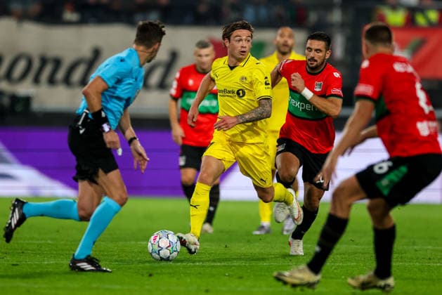 NIJMEGEN, NETHERLANDS - AUGUST 19: Patrick Berg of FK Bodo Glimt dribbles with the ball under pressure from Dusan Tadic of NEC Nijmegen during the UEFA Champions League 2026 27 play-offs first leg match between N.E.C. Nijmegen and FK Bodo Glimt at Goffertstadion on August 19, 2026 in Nijmegen, Netherlands.  Copyright: xRenexNijhuis MBxMediax
