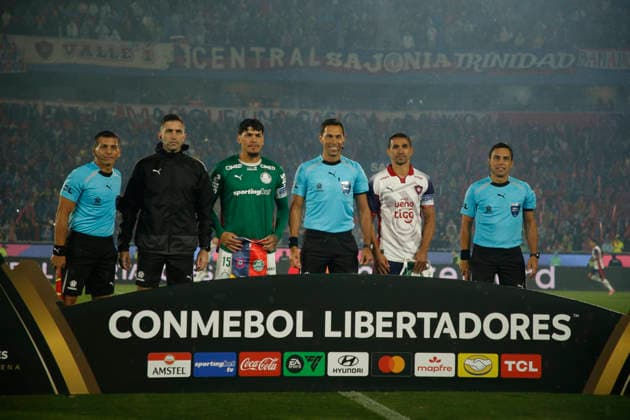 Palmeiras captain Gustavo Gomez (3rd L) and Cerro Porteno player Jorge Morel (2nd R) pose with match referee Facundo Tello (C) and the officiating crew during the pennant exchange. Club Cerro Porteno v SE Palmeiras - Copa Libertadores Round of 16 second leg match - ASUNCION, PARAGUAY - AUGUST 19, 2026 Copyright: xSoccerxImagesx