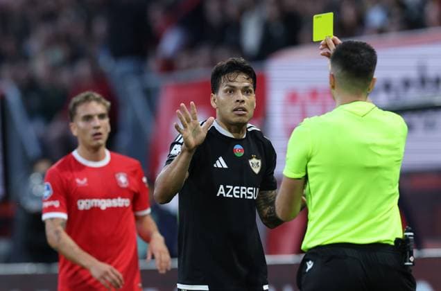 ENSCHEDE - scheidsrechter Juxhin Xhaja geeft gele kaart aan FC Twente verdediger Aske Adelgaard en FK Qarabag verdediger Matheus Silva tijdens de UEFA Conference League wedstrijd tussen FC Twente en FK Qarabag in Golsch Veste op 20 augustus 2026 in Enschede , Nederland. - *** ENSCHEDE referee Juxhin Xhaja shows yellow cards to FC Twente defender Aske Adelgaard and FK Qarabag defender Matheus Silva during the UEFA Conference League match between FC Twente and FK Qarabag at Golsch Veste on August 20, 2026, in Enschede, the Netherlands
