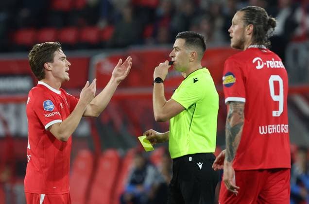 ENSCHEDE - scheidsrechter Juxhin Xhaja geeft gele kaart aan FC Twente aanvaller Daan Rots tijdens de UEFA Conference League wedstrijd tussen FC Twente en FK Qarabag in Golsch Veste op 20 augustus 2026 in Enschede , Nederland. - *** Enschede referee Juxhin Xhaja shows a yellow card to FC Twente forward Daan Rots during the UEFA Conference League match between FC Twente and FK Qarabag at Golsch Veste on August 20, 2026, in Enschede, Netherlands