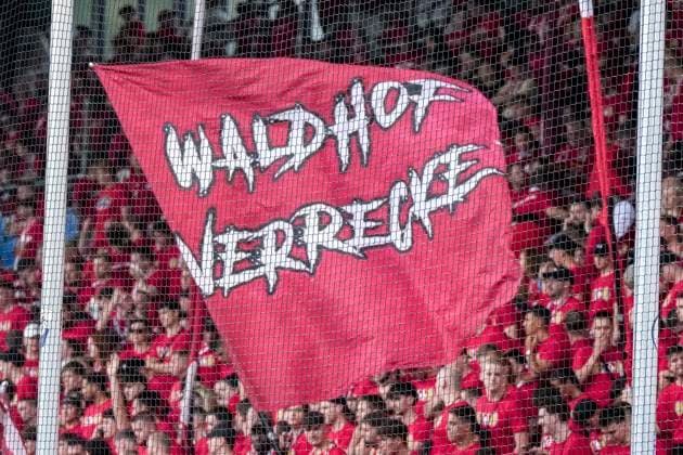 Die mitgereisten Ultras vom 1. FC Kaiserslautern schwenken in der Fankurve ihre Fahnen mit der Aufschrift: Waldhof verrecke, Gästefans, Gästeblock, Gast, Fanblock, freuen sich aufs Spiel, Fans, Publikum, Zuschauer, Stimmung, Atmosphäre, Stadion, 21.08.2026, Mannheim (Deutschland), Fussball, DFB-Pokal, 1. Runde, SV Waldhof Mannheim - 1. FC Kaiserslautern, DFB DFL REGULATIONS PROHIBIT ANY USE OF PHOTOGRAPHS AS IMAGE SEQUENCES AND OR QUASI-VIDEO. *** The Ultras from 1 FC Kaiserslautern who traveled with the team are waving their flags in the fan section bearing the slogan Waldhof verrecke ; visiting fans, visiting section, visitors, fan section, looking forward to the game, fans, audience, spectators, mood, atmosphere, stadium, August 21, 2026, Mannheim, Germany, soccer, DFB Cup, 1st round, SV Waldhof Mannheim vs. 1 FC Kaiserslautern, DFB and DFL regulations prohibit any use of photographs as image sequences and or quasi-video xozx