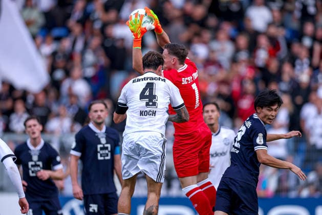 21.08.2026, Fußball, SC St. Tönis - Eintracht Frankfurt, 1. Runde DFB-Pokal 2026 27, Grotenburg-Stadion in Krefeld, Saison 2026 2027: Torwart Simon Sell (SC St. Tönis 01) verteidigt gegen Robin Koch (Eintracht Frankfurt 04) DFB regulations prohibit any use of photographs as image sequences and or quasi-video. Nordrhein-Westfalen Deutschland *** August 21, 2026, Soccer, SC St. Tönis vs. Eintracht Frankfurt, 1st Round of the 2026–27 DFB Cup, Grotenburg Stadium in Krefeld, 2026–2027 season: Goalkeeper Simon Sell of SC St. Tönis 01 defends against Robin Koch of Eintracht Frankfurt 04. DFB regulations prohibit any use of photographs as image sequences and or quasi-video. North Rhine-Westphalia, Germany