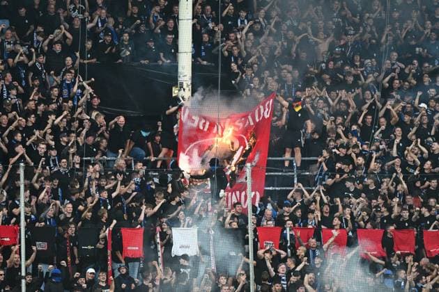 Im Fanblock des SV Waldhof Mannheim wird im Carl-Benz-Stadion eine rote Fahne mit Feuer angezündet und verbrannt, während die Zuschauer jubeln und die Fäuste recken. Dichter Rauch steigt auf, die Tribüne ist vollständig gefüllt mit überwiegend schwarz gekleideten Fans. Waldhof-Fans verbrennen Fahne im Carl-Benz-Stadion Mannheim *** In the SV Waldhof Mannheim fan section at Carl Benz Stadium, a red flag is set on fire and burned while the spectators cheer and raise their fists. Thick smoke rises; the stands are completely filled with fans dressed mostly in black. Waldhof fans burn a flag at Carl Benz Stadium in Mannheim Copyright: xMichaelxGelhardtx