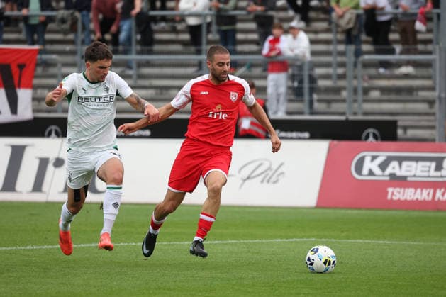 Elias Vali Fard (MG) li. gegen Serhat Semih Gueler (Güler) (SI) Fussball Regionalliga West, 4. Spieltag, Sportfreunde Siegen - Borussia Moenchengladbach (Mönchengladbach) U23, am 21.08.2026 in Siegen Deutschland. *** Elias Vali Fard MG li vs. Serhat Semih Gueler Güler SI, Regional League West soccer, Matchday 4, Sportfreunde Siegen vs. Borussia Mönchengladbach U23, on August 21, 2026, in Siegen, Germany