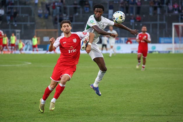 Elsamed Ramaj (SI) li. gegen Divine Dillon Berko (MG) re. Fussball Regionalliga West, 4. Spieltag, Sportfreunde Siegen - Borussia Moenchengladbach (Mönchengladbach) U23, am 21.08.2026 in Siegen Deutschland. *** Elsamed Ramaj (SI) vs. Divine Dillon Berko (MG) – Regional League West soccer, Matchday 4, Sportfreunde Siegen vs. Borussia Mönchengladbach U23, on August 21, 2026, in Siegen, Germany