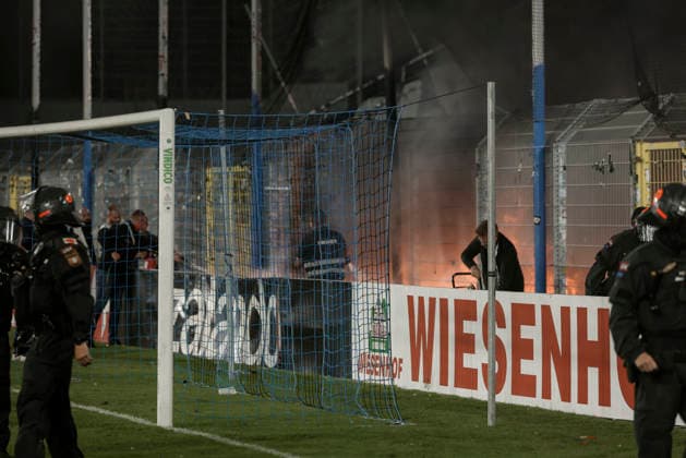 21.08.2026, xhettx, Fussball DFB Pokal 1.Runde, SV Waldhof Mannheim - 1.FC Kaiserslautern v.l. Lauternfans legen ein Feuer im Gästeblock (DFL DFB REGULATIONS PROHIBIT ANY USE OF PHOTOGRAPHS as IMAGE SEQUENCES and or QUASI-VIDEO) *** August 21, 2026, xhettx, Soccer DFB Cup First Round, SV Waldhof Mannheim 1, FC Kaiserslautern; Lautern fans set a fire in the visitors section. DFL and DFB regulations prohibit any use of photographs as image sequences and or quasi-video.