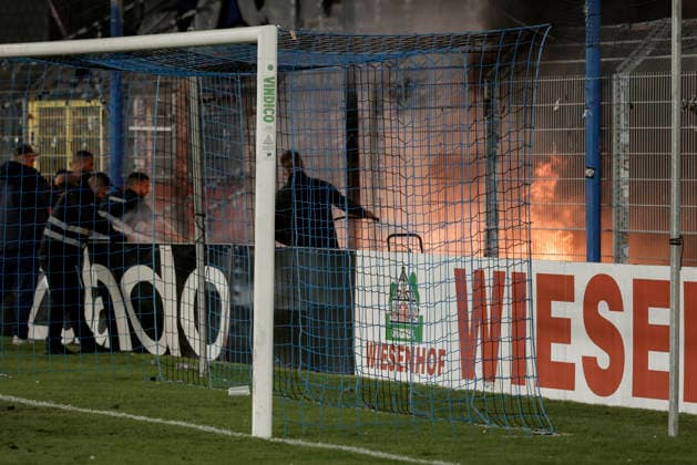 21.08.2026, xhettx, Fussball DFB Pokal 1.Runde, SV Waldhof Mannheim - 1.FC Kaiserslautern v.l. Lauternfans legen ein Feuer im Gästeblock (DFL DFB REGULATIONS PROHIBIT ANY USE OF PHOTOGRAPHS as IMAGE SEQUENCES and or QUASI-VIDEO) *** August 21, 2026, xhettx, Soccer DFB Cup First Round, SV Waldhof Mannheim 1, FC Kaiserslautern; Lautern fans set a fire in the visitors section. DFL and DFB regulations prohibit any use of photographs as image sequences and or quasi-video.