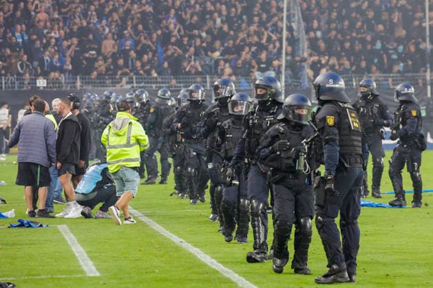 Im Bild: Ausschreitungen der Fanlager, die Polizei muss eingreifen und das Feld stuermen. 21.08.2026, SV Waldhof Mannheim 07 - 1. FC Kaiserslautern, DFB-Pokal, 1. Runde, Deutschland, Mannheim, Carl-Benz-Stadion, DFL REGULATIONS PROHIBIT ANY USE OF PHOTOGRAPHS AS IMAGE SEQUENCES AND OR QUASI-VIDEO. *** The photo shows riots among the fan groups; the police are forced to intervene and storm the field, August 21, 2026, SV Waldhof Mannheim 07 vs. 1 FC Kaiserslautern, DFB Cup, First Round, Germany, Mannheim, Carl Benz Stadium. DFL regulations prohibit any use of photographs as image sequences and or quasi-video. Copyright: HMBxMedia xJulienxBecker