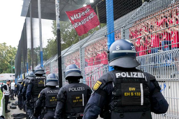 Erhöhtes Polizeiaufkommen bei der Partie, Polizisten im Stadion, Polizeipräsenz, Polizeischutz, Polizei im Einsatz, Sicherheit, Stadionsicherheit, Symbolfoto, Symbolbild, Symbol, Risikospiel, Hochsicherheitsspiel, Fußballspiel mit einem erhöhten Sicherheitsrisiko, das Spiel wurde im Vorfeld als Hochrisikospiel eingestuft, Fans des 1. FC Kaiserslautern mit einer Fahne: Waldhof verrecke, 21.08.2026, Mannheim (Deutschland), Fussball, DFB-Pokal, 1. Runde, SV Waldhof Mannheim - 1. FC Kaiserslautern, DFB DFL REGULATIONS PROHIBIT ANY USE OF PHOTOGRAPHS AS IMAGE SEQUENCES AND OR QUASI-VIDEO. *** Increased police presence at the match, police officers in the stadium, police presence, police protection, police on duty, security, stadium security, stock photo, symbolic image, symbol, high-risk match, high-security match, soccer match with an increased security risk; the match was classified as a high-risk match in advance, 1 FC Kaiserslautern fans holding a Waldhof verrecke flag, August 21, 2026, Mannheim, Germany, soccer, DFB Cup, 1st round, SV Waldhof Mannheim vs. 1 FC Kaiserslautern, DFB DFL regulations prohibit any use of photographs as image sequences and or quasi-video xozx