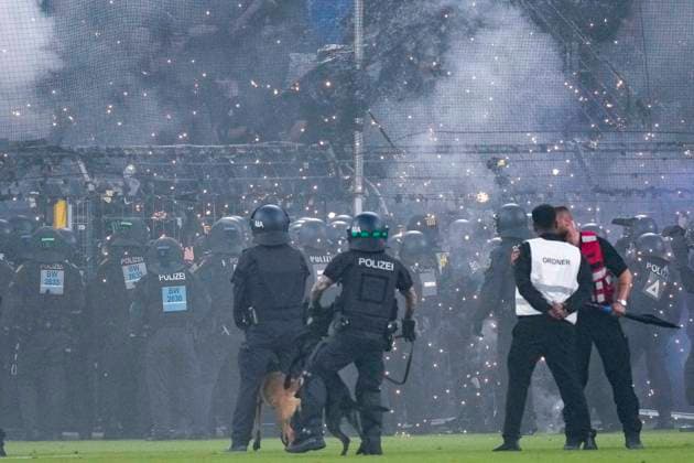 Polizisten sichern das Spielfeld nach Pyroattacken von den Rängen, Erhöhtes Polizeiaufkommen bei der Partie, Polizisten im Stadion, Polizeipräsenz, Polizeischutz, Polizei im Einsatz, Sicherheit, Stadionsicherheit, Symbolfoto, Symbolbild, Symbol, Risikospiel, Hochsicherheitsspiel, Fußballspiel mit einem erhöhten Sicherheitsrisiko, das Spiel wurde im Vorfeld als Hochrisikospiel eingestuft, 21.08.2026, Mannheim (Deutschland), Fussball, DFB-Pokal, 1. Runde, SV Waldhof Mannheim - 1. FC Kaiserslautern, DFB DFL REGULATIONS PROHIBIT ANY USE OF PHOTOGRAPHS AS IMAGE SEQUENCES AND OR QUASI-VIDEO. *** Police officers secure the field after pyrotechnic attacks from the stands; increased police presence at the game; police officers in the stadium; police presence, police protection, police in action, security, stadium security, stock photo, stock image, symbol, high-risk game, high-security game, soccer game with an increased security risk, the game was classified as a high-risk game in advance, August 21, 2026, Mannheim, Germany, soccer, DFB Cup, 1st round, SV Waldhof Mannheim vs. 1. FC Kaiserslautern, DFB and DFL regulations prohibit any use of photographs as image sequences and or quasi-video xozx